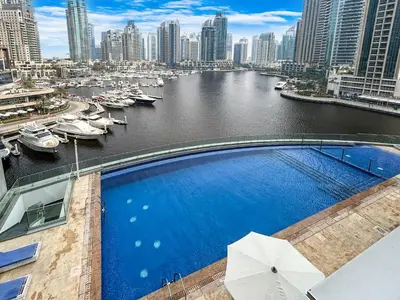 a large swimming pool on a building next to a river at 44th Floor Home at Cayan Tower with Panoramic Views in Dubai