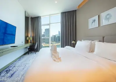 a hotel room with a large bed and a tv at Sleek & Stylish Studio in DAMAC Prive, Dubai in Dubai