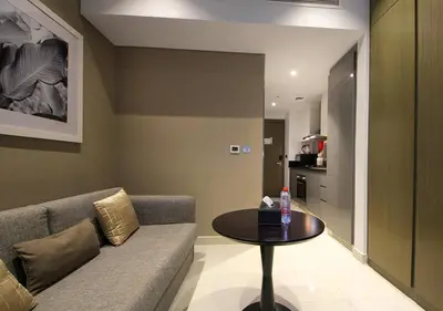 a living room with a couch and a table at Sleek & Stylish Studio in DAMAC Prive, Dubai in Dubai