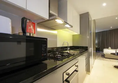 a kitchen with a microwave and a stove top oven at Sleek & Stylish Studio in DAMAC Prive, Dubai in Dubai