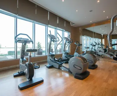 a gym with several exercise bikes in a room with windows at Sleek & Stylish Studio in DAMAC Prive, Dubai in Dubai