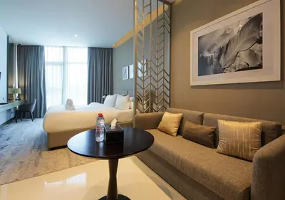 a hotel room with a couch and a bed at Sleek & Stylish Studio in DAMAC Prive, Dubai in Dubai