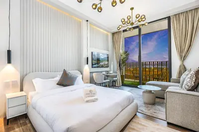 a bedroom with a white bed and a living room at FIRST CLASS Studio Stylish Comfort in Dubai