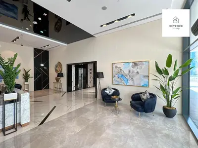 a lobby with two chairs and a painting on the wall at KeyRock Living - 20th Floor Comfort at Zada in Dubai