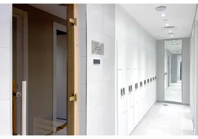 a hallway with white tile walls and a mirror at KeyRock Living - 20th Floor Comfort at Zada in Dubai