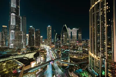 a city skyline at night with a lot of buildings at Burj Khalifa View & Mall Entry in 3 Mins & Sleeps 3 Adults in Dubai