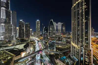 a view of a city at night with traffic at Burj Khalifa View & Mall Entry in 3 Mins & Sleeps 3 Adults in Dubai