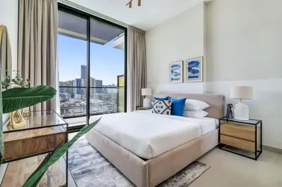 a bedroom with a large bed and a large window at GuestReady - Jumeirah Village haven with pool view in Dubai