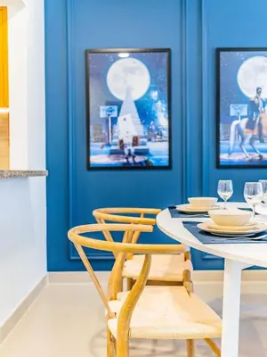 a dining room with blue walls and a table and chairs at Chic Getaway with Balcony & Burj Khalifa View in Dubai