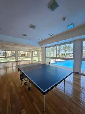 a ping pong table in a room with a swimming pool at Marina Residence 6 - Luxurious Two Bedroom and Maid's - Lake and Sea View in Dubai