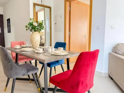 a dining room table with chairs and a vase of flowers at Burj Khalifa Panoramic view-1BR,4 guests, Downtown in Dubai