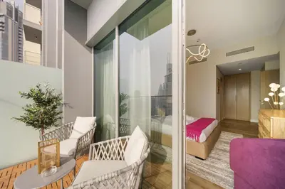 a room with a balcony with a bedroom at Gogoto3 High Floor Burj Khalifa NYE Fireworks View PS5 in Dubai