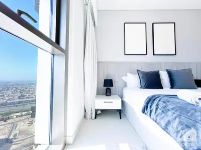 a white bedroom with a bed and a window at Burj Crown Luxurious 2Bedroom Balcony in Dubai