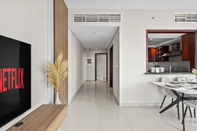 a kitchen and dining room with a tv and a table at 29 Boulevard - Luxury 2BR Apartment with Burj Khalifa & Fountain View in Dubai