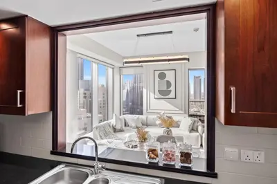 a kitchen with a view of a living room at 29 Boulevard - Luxury 2BR Apartment with Burj Khalifa & Fountain View in Dubai