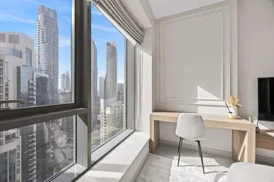 a bedroom with a desk and a large window at 29 Boulevard - Luxury 2BR Apartment with Burj Khalifa & Fountain View in Dubai