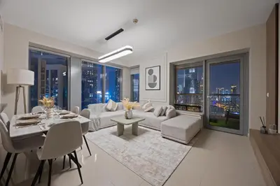 a living room with a couch and a table and chairs at 29 Boulevard - Luxury 2BR Apartment with Burj Khalifa & Fountain View in Dubai
