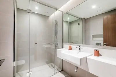 a bathroom with a sink and a glass shower at Luxury 2BR Apartment Burj Khalifa View in Al Safa in Dubai