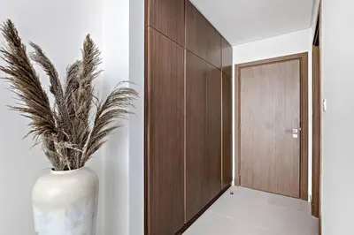 a large white vase with a plant in a hallway at Luxury 2BR Apartment Burj Khalifa View in Al Safa in Dubai