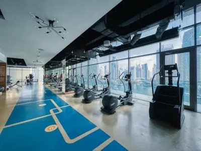 a gym with a lot of treadmills and machines at Vogue Marina Gate near JBR Beach and Marina Mall, One Bedroom Apartment with Balcony and city skyline view, Access to all Amenities in Dubai