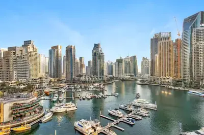 a harbor with boats in a city with buildings at Vogue Marina Gate near JBR Beach and Marina Mall, One Bedroom Apartment with Balcony and city skyline view, Access to all Amenities in Dubai