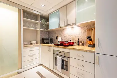 a kitchen with white cabinets and a white refrigerator at Luxury Stay - Private Jacuzzi - Infinity Pool - Marina & Sea Views - High Floor - Upgraded - Designer - Squash in Dubai