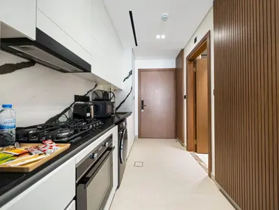 a kitchen with a stove top oven next to a hallway at Modern Studio Private Jacuzzi Canal View in Dubai