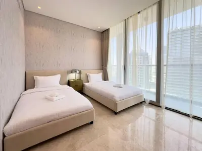 two beds in a hotel room with large windows at Modern & Stylish 2BR Apartment in Dubai