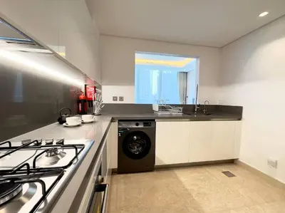 a kitchen with a washer and dryer in it at Modern & Stylish 2BR Apartment in Dubai