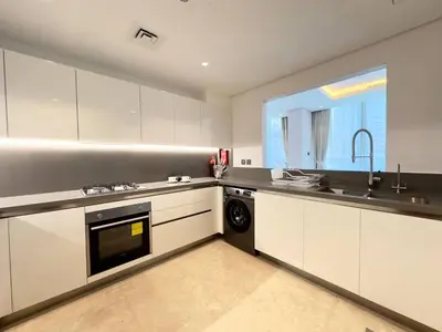 a kitchen with white cabinets and a sink and a dishwasher at Modern & Stylish 2BR Apartment in Dubai