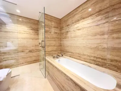 a bathroom with a tub and a glass shower at Unique Luxury White 2BR Apartment in Dubai