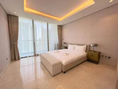 a bedroom with a large white bed and large windows at Unique Luxury White 2BR Apartment in Dubai