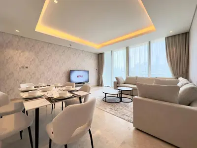 a living room with a table and chairs and a television at Contemporary Urban 2BR Apartment in Dubai