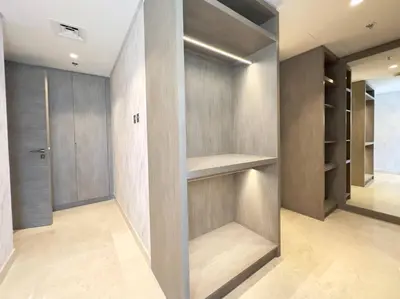 a walk in closet with wooden doors and shelves at Contemporary Urban 2BR Apartment in Dubai