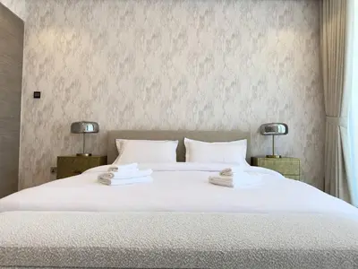 a bedroom with a large white bed with two lamps at Contemporary Urban 2BR Apartment in Dubai