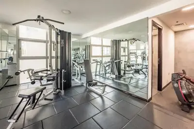a gym with treadmills and ellipticals and mirrors at Stunning Newly Furnished Elegant LUX Apartment in Dubai