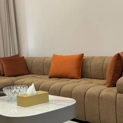 a living room with a couch and a table at Spacious Designer Home Pool, Gym & Playground in Dubai