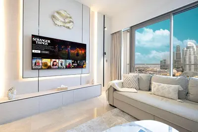 a living room with a couch and a large window at 2BR Burj & Fountain View 5 mins to Dubai Mall in Dubai