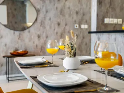 a table with plates and glasses of orange juice at Spectacular Burj View from Infinity Pool in Dubai