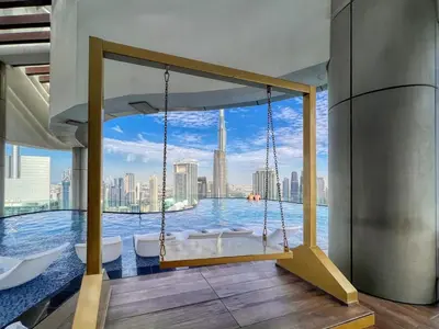 a swing in a pool with a view of the city at Spectacular Burj View from Infinity Pool in Dubai