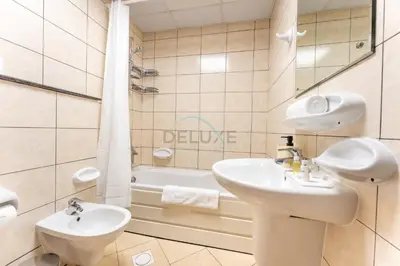 a bathroom with two sinks and a bath tub at Walk to Metro, Tram & Beach, Stylish 1BR in Marina Pinnacle, Dubai Marina by Deluxe Holiday Homes in Dubai
