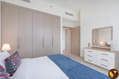a bedroom with a white bed and a dresser at Vogue Downtown Act One near Burj Khalifa and Dubai Mall, Two Bedroom Apartment with Balcony and City Skyline View, Access to All Amenities in Dubai