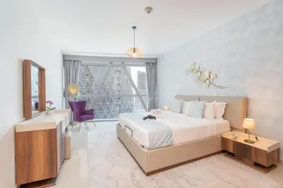 a bedroom with a bed and a desk and a window at StayShort - Stylish DIFC Apartment Sleeps 4 with Pool & Gym in Dubai