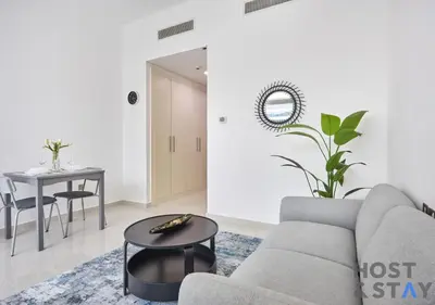 a living room with a couch and a table at Bright Studio in Loreto DAMAC Hills - Pet-Friendly in Dubai