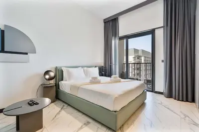 a bedroom with a large bed and a balcony at PVH - Serene Studio minutes to Downtown - MAG Eye in Dubai