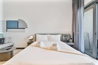 a bedroom with a large bed with two towels on it at PVH - Serene Studio minutes to Downtown - MAG Eye in Dubai
