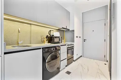 a kitchen with a washing machine and a sink at PVH - Serene Studio minutes to Downtown - MAG Eye in Dubai