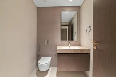 a bathroom with a toilet and a sink and a mirror at Werova - Luxury 2-Bedroom Apartment with Sea View in Dubai