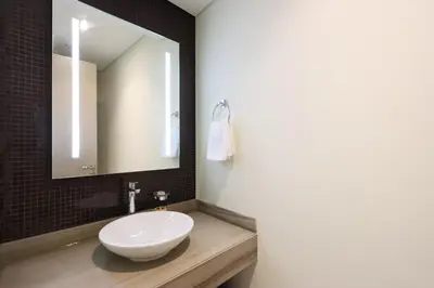 a bathroom with a white sink and a mirror at Stylish 2BR Paramount Apt Near Downtown in Dubai