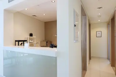 a kitchen with a white counter and a hallway at Stylish 2BR Paramount Apt Near Downtown in Dubai